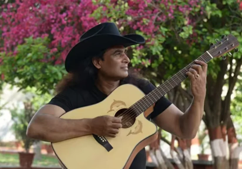 Indian country singer Bobby Cash with his guitar wearing a cowboy hat
